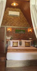 a large bed in a room with a brick wall at NJ House in Tangalle