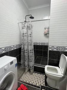 La salle de bains est pourvue de toilettes et d'un lave-linge. dans l'établissement Красивая квартира в центре городе Шымкент. ЖК Аль-Фараби, à Chimkent