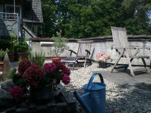 einen Garten mit Stühlen und Blumen im Hof in der Unterkunft Tor zum Bodensee in Stockach