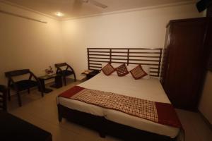 um quarto com uma cama grande e almofadas vermelhas em Hotel Clark Height @New Delhi em Nova Deli