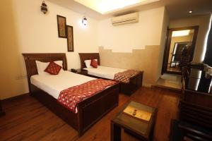 a hotel room with two beds and a mirror at Hotel Clark Height @New Delhi in New Delhi