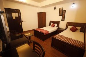新德里的住宿－Hotel Clark Height @New Delhi，小酒店客房设有两张床和一张桌子。