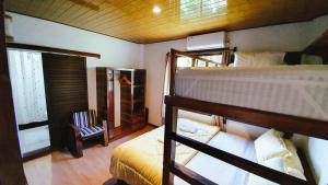 a bedroom with two bunk beds and a chair at Jamburae Lodge in Lagudri