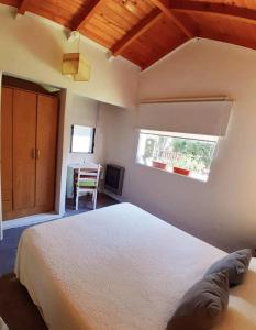 Un dormitorio con una cama grande y una ventana en Casa con jardín - Circuito Chico, Bariloche en San Carlos de Bariloche