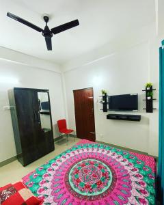 Un dormitorio con una cama con una alfombra colorida. en Ashirwad Homestay, en Dibrugarh