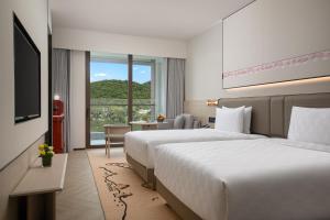 三亞的住宿－三亚亚龙湾星华华邑度假酒店（首日迷你吧免费），酒店客房设有两张床和电视。