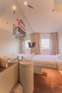 a bedroom with two beds and a sink at J Icon Hip Hotel in Balikpapan