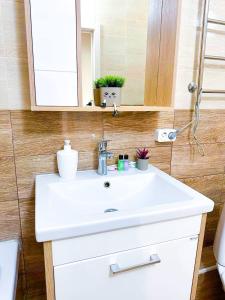 a bathroom with a white sink and a mirror at New 1 bedroom рядом ханшатыр in Astana