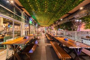 a row of wooden benches in a restaurant with lights at J Icon Hip Hotel in Balikpapan