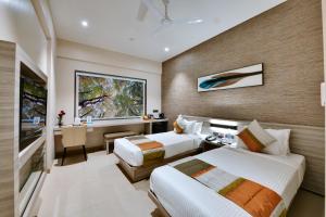 a hotel room with two beds and a desk at Click Hotel Pithampur in Mhow