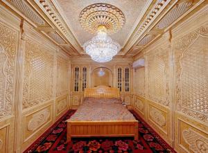 um quarto com uma cama num quarto com um lustre em Good Morning Homestay Inn em Kashgar
