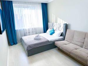 a small bedroom with a bed and a couch at New 1 bedroom рядом ханшатыр in Astana