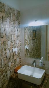 y baño con lavabo blanco y espejo. en Jawai Leopard Villa, en Bijāpur