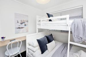 a small room with bunk beds and a chair at Coastal convenience! Walk to the shops & cafes... in Perth