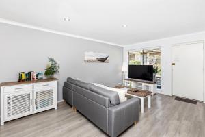 a living room with a couch and a tv at Coastal convenience! Walk to the shops & cafes... in Perth