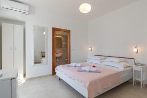 Dormitorio blanco con cama con manta rosa en guesthouse Libertas 1 en Dubrovnik