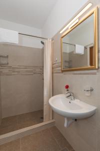 a bathroom with a sink and a shower with a mirror at guesthouse Libertas 1 in Dubrovnik