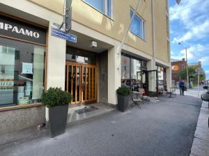uma frente de loja com dois vasos de plantas em frente em STAY Kamppi Apartment em Helsinque