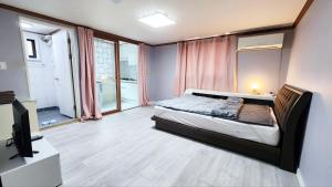 1 dormitorio con 1 cama y TV en The house of gallery en Daegu