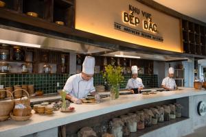 un grupo de chefs que preparan comida en una cocina en The Coffee City - Healing & Retreats, en Buon Ma Thuot