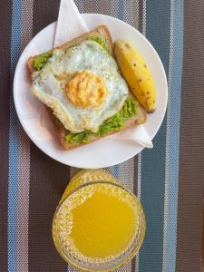 a sandwich with an egg and a banana on a plate at Henotes B&B in Kamuli