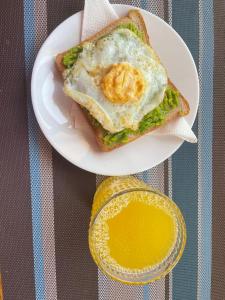a sandwich with an egg on a plate on a table at Henotes B&B in Kamuli
