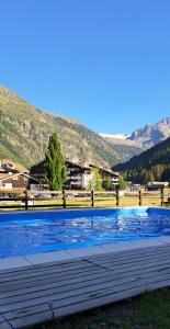 una piscina en un campo con montañas en el fondo en La Thuile bilocale frazione Entrèves Condominio Ametista 30, en La Thuile
