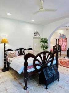 een slaapkamer met een bed met een houten frame bij Anandmai Heritage Homestay in Jaipur