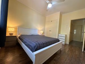 1 dormitorio con 1 cama, vestidor y lámpara en Broome, en Broome