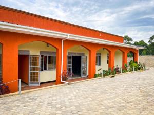 an orange and white building with a courtyard at NB MOTEL-KIHIHI in Kihihi
