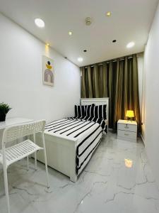 sypialnia z łóżkiem, krzesłem i oknem w obiekcie DSV Property w Abu Zabi