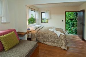 モンテベルデ・コスタリカにあるThe Cloud Forest Magical Villaのベッドルーム1室(ベッド2台、ソファ付)