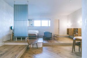Habitación con cama, mesa y sillas. en haluta hotelli still en Karuizawa
