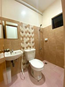 a bathroom with a toilet and a sink at Torres Traveller's Inn 