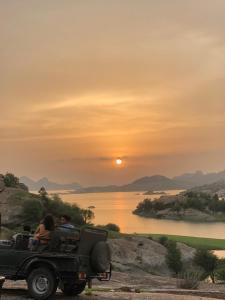 a group of people riding in a jeep at sunset at Jawai Leopard Villa in Bijāpur