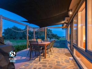 eine Terrasse mit einem Holztisch und Stühlen darauf in der Unterkunft Nordic Retro Beach House at Port Elliot in Port Elliot