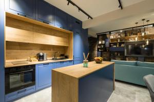 a kitchen with blue cabinets and a wooden island at Egoist Boutique Suites in Veliko Tŭrnovo