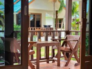 Tiki Beach Koh Phangan في بان تاي: طاولة وكراسي خشبية على شرفة
