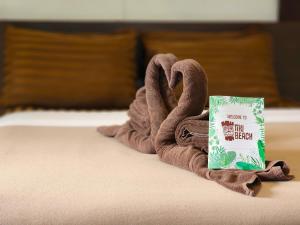 un asciugamano a forma di cigno su un letto con un libro di Tiki Beach Koh Phangan a Baan Tai