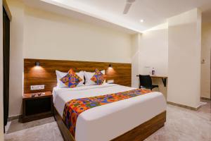 a bedroom with a large bed and a desk at FabExpress Antlers - Nr Boriwali in Mumbai