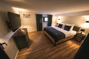 a hotel room with a bed and a television at Eifellodge - am roten Sandberg in Prüm