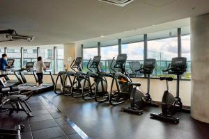 ein Fitnessstudio mit einem Haufen Heimtrainern und Menschen darin in der Unterkunft Modern Elegance 2BR Luxury Apartment with Gym & Pool in Melbourne