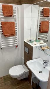 een witte badkamer met een toilet en een wastafel bij Apartament Welle Lazurowy PREMIUM Grzybowo in Grzybowo
