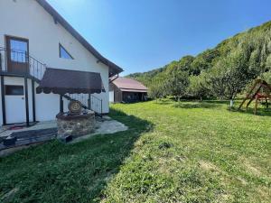 a house with a grass yard next to a building at Amza House in Robaia