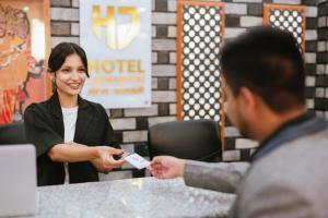a woman is handing a man a wii remote at Hotel Janmabhumi in Pashupatināth