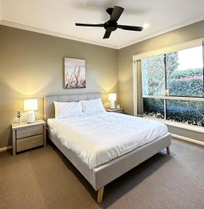 a bedroom with a bed and a ceiling fan at Luxury Holiday Home in Middle Ridge Toowoomba in Harristown