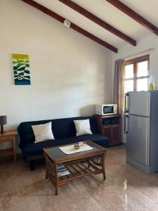 a living room with a blue couch and a refrigerator at Maison Marikel in Mahe