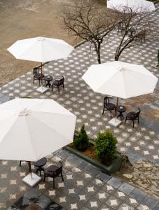 un grupo de mesas con sombrillas blancas en The Gate Boutique Hotel Sapa en Sa Pa