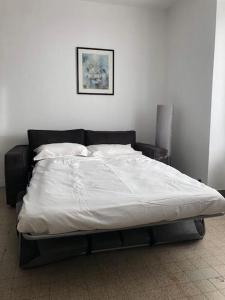 - un grand lit dans une chambre dotée d'un couvre-lit blanc dans l'établissement Appartement proche du PAL, à Dompierre-sur-Besbre