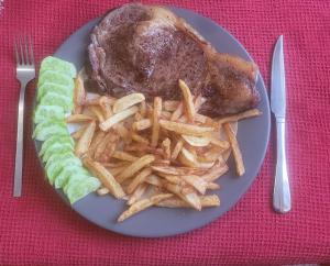 une assiette de nourriture avec un poulet et des frites dans l'établissement Appartement proche du PAL, à Dompierre-sur-Besbre